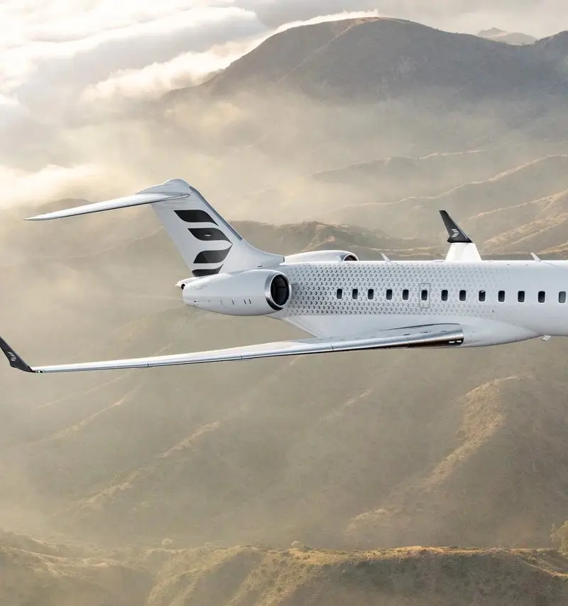 The sleek Bombardier Global 6500 private jet flies gracefully above misty mountains near Madrid, showcasing its elegant design.
