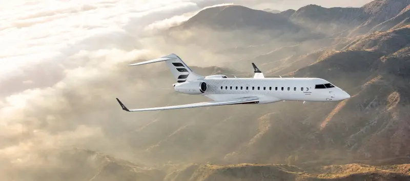 Bombardier Global 6500 — Flying over Madrid mountains The sleek Bombardier Global 6500 private jet flies gracefully above misty mountains near Madrid, showcasing its elegant design.