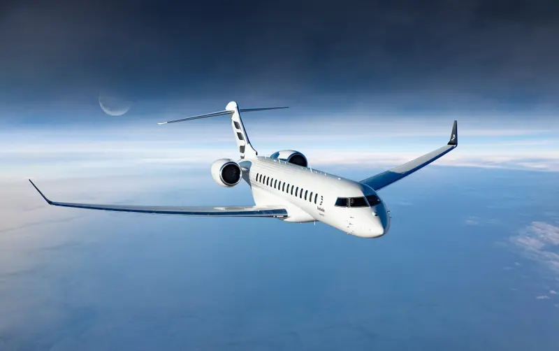 Bombardier Global 8000 — In-flight over Marbella The Bombardier Global 8000 private jet flies high above the clouds with a crescent moon in the dark sky, available for charter from Marbella.