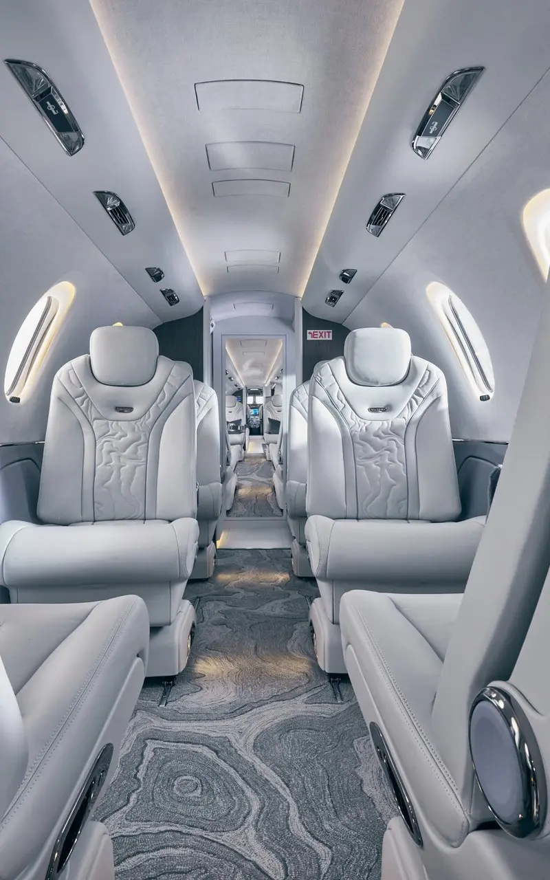Cessna Citation XLS+ — Luxurious private jet interior The Cessna Citation XLS+ cabin interior features luxurious light grey leather seats and a patterned aisle carpet, ready for departure from Marbella.