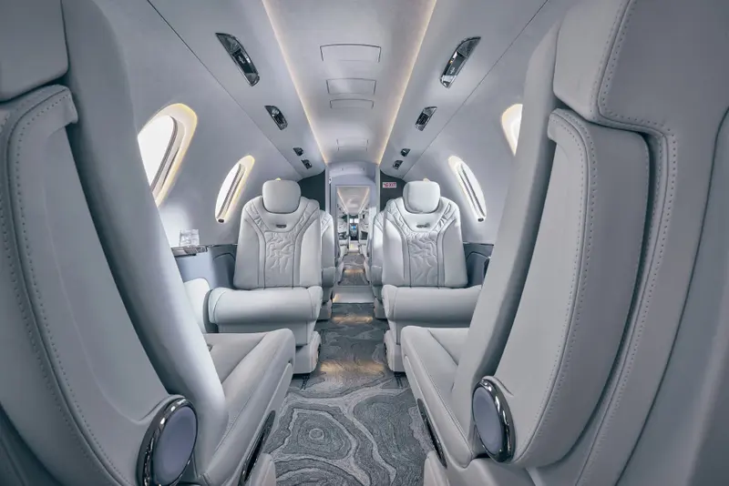 Cessna Citation XLS+ — Luxurious private jet interior The Cessna Citation XLS+ cabin interior features luxurious light grey leather seats and a patterned aisle carpet, ready for departure from Marbella.