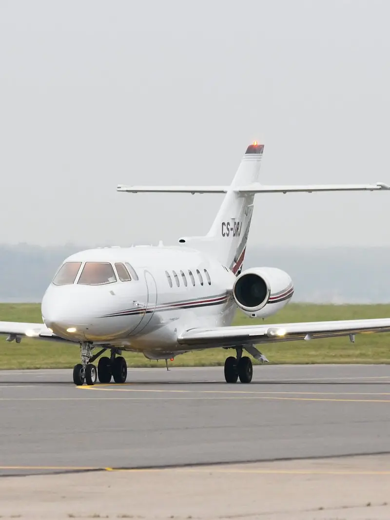 Hawker 800XP — Ready for departure in Barcelona The Hawker 800XP private jet is seen from a front-three-quarter view on the tarmac at Barcelona airport, ready for departure.