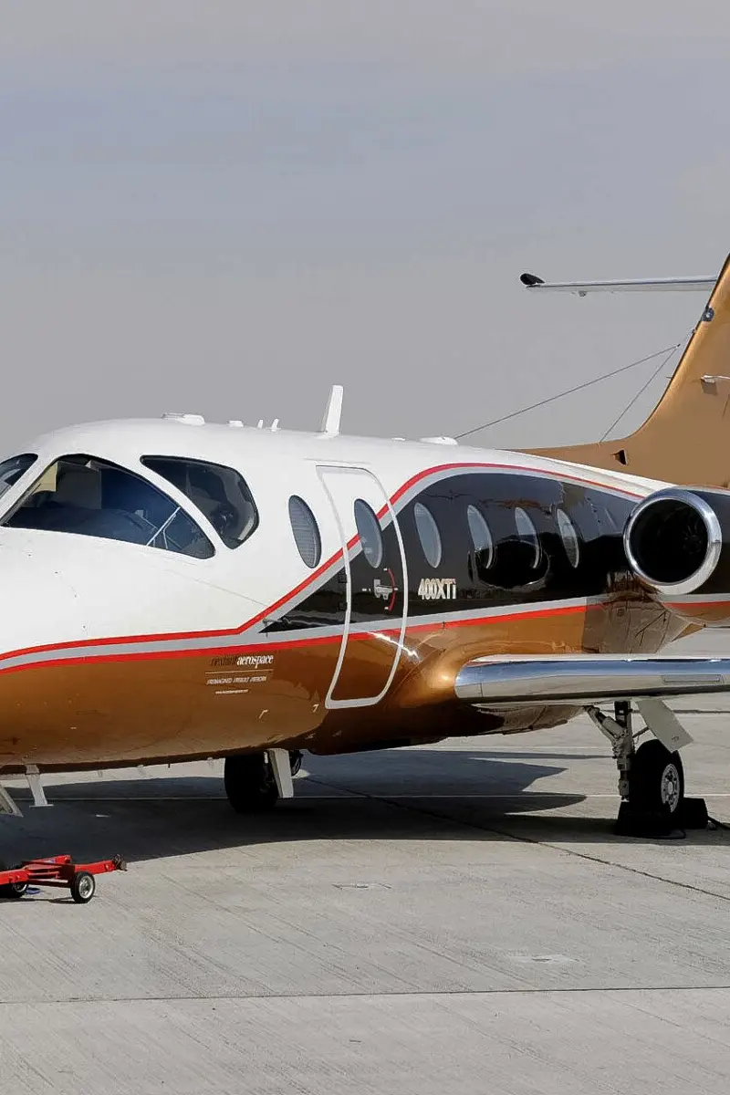 Nextant 400XTi — Exterior view on tarmac The Nextant 400XTi light jet, with its distinctive white and gold livery, parked on a sunlit tarmac in Marbella.